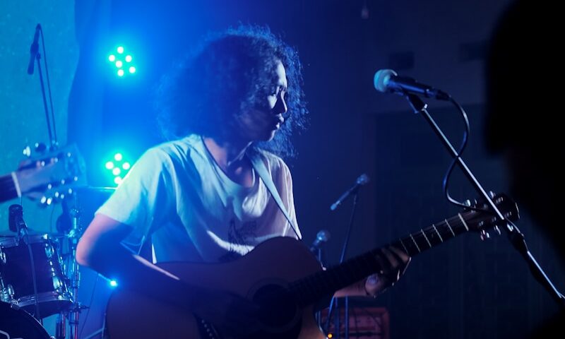 man playing guitar on stage