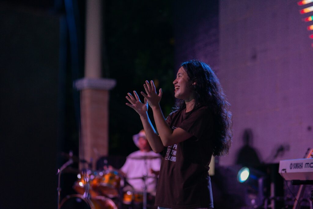 A woman standing on a stage with her hands in the air